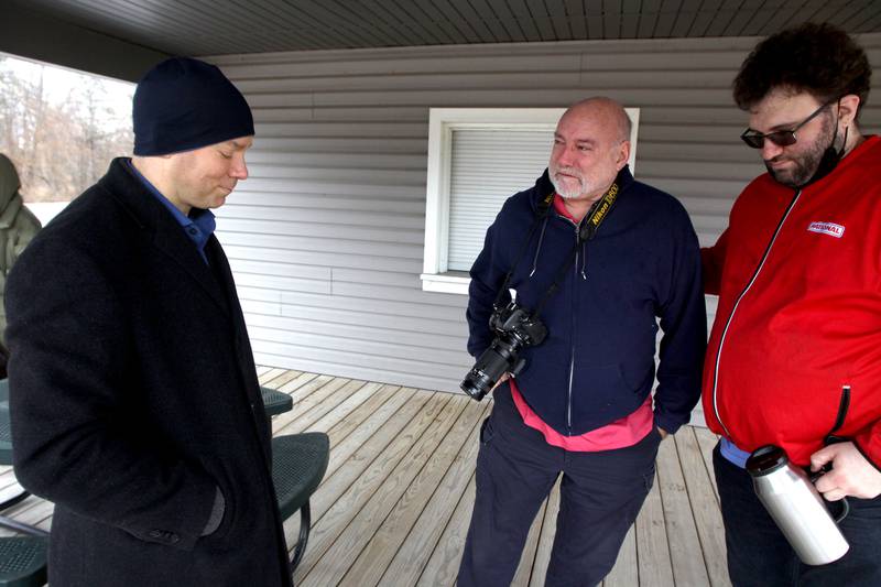 Former Wonder Lake Fire Protection District first responder Pete Diedrich, center, on Saturday visits with Brian Nicosia, left, near the scene of a 1982 midair military jet explosion that happened over the small, rural area northeast of Woodstock. Nicosia’s father and 26 others were killed as the plane exploded midair at 9:11 p.m. Diedrich was among the first on the scene, and had the grim task of pulling the deceased crew from the wreckage. Nicosia’s father, Co-pilot Capt. Robert J. Nicosia of Algonquin, was among the crew. In all the years since the explosion, Saturday was the first occasion Diedrich had to visit with any of the crew’s loved ones. Diedrich’s son Nick is at right.