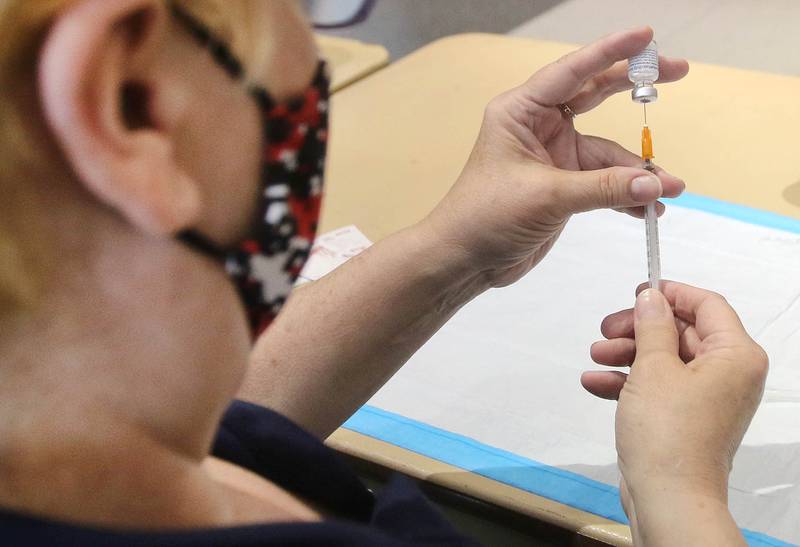 Cindy Graves, operations chief with the DeKalb County Health Department fills syringes with the COVID-19 vaccine in May 2021 during a clinic at the Convocation Center at Northern Illinois University in DeKalb