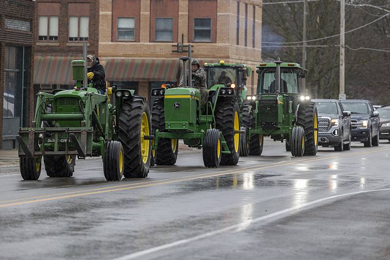 A trio of John Deere tractors lead a section of mourners Thursday, April 4, 2024 during the funeral procession of Jayden Hanson.
