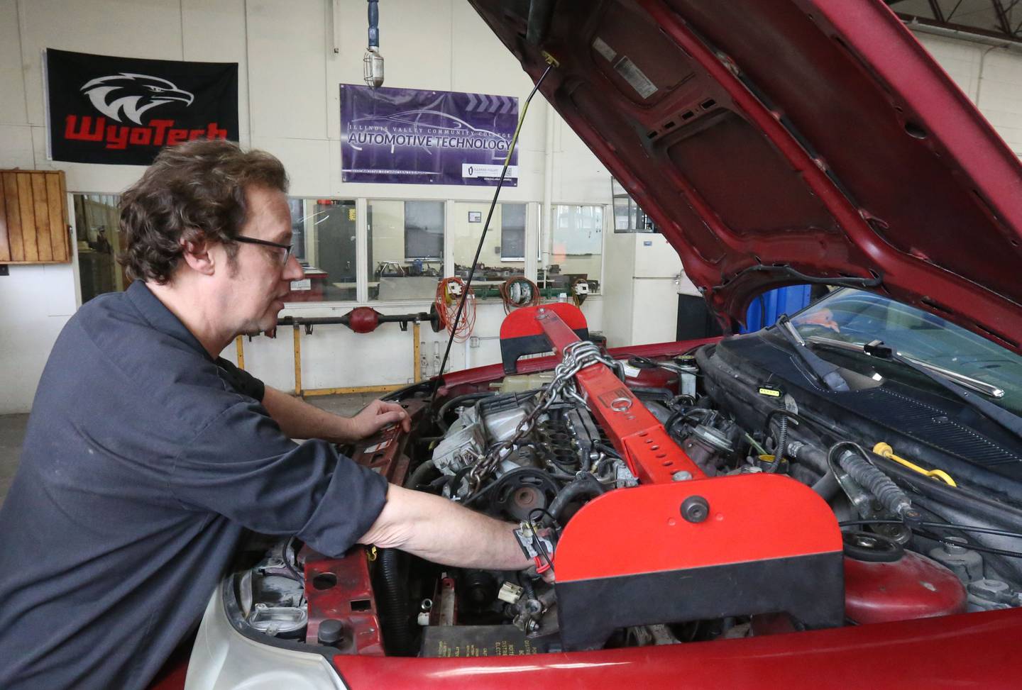 Area Career Center auto instructor Mike Fisher, checks oil level on a vehicle on Wednesday, April 26, 2025 at La Salle-Peru Township High School.