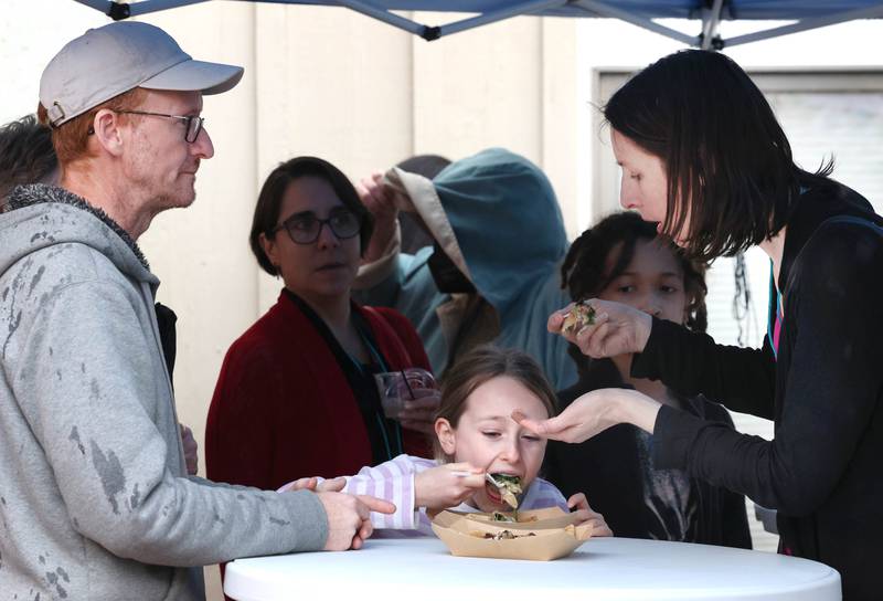 Tim Horsley, (left) Clara McKee-Horsley, 8, and Emily McKee, from DeKalb, enjoy a bite to eat Thursday, April 18, 2024, during Earth Fest at the Egyptian Theatre in DeKalb. The event, in honor of Earth Week, was presented by DeCarbon DeKalb, in partnership with NIU.