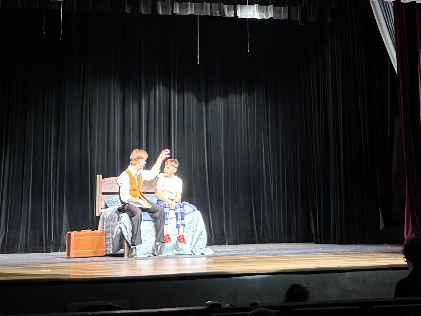 Liam Eber, who plays Edward, comforts a younger version of the character Will near the beginning of Morris Community High School's performance of "Big Fish" on Monday, April 28, 2025.