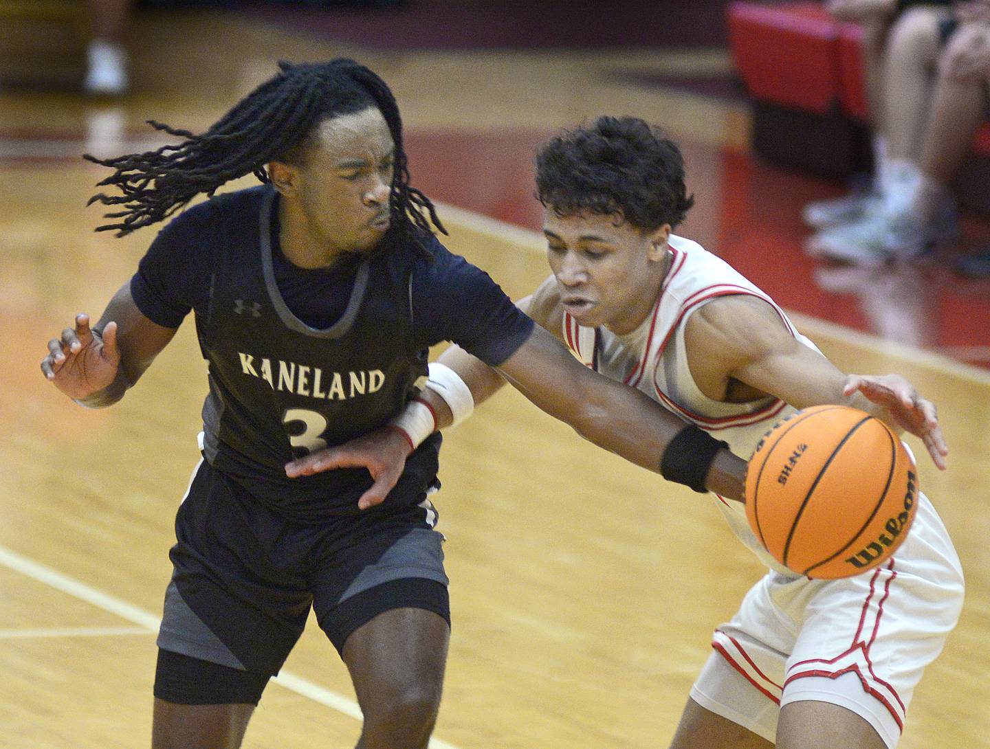 Kaneland’s Marshawn Cocroft works to steal the ball from Ottawa’s Hezekiah Joachim in the 2nd quarter Tuesday at Ottawa.