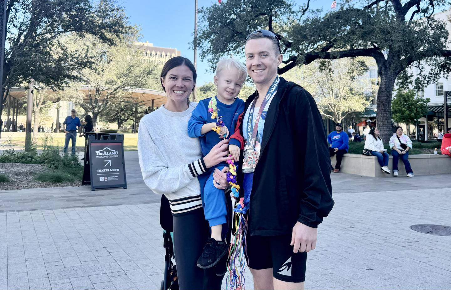 Colin Mickow celebrates winning the San Antonio Marathon on Sunday with his wife, Melissa, and son, Finn.