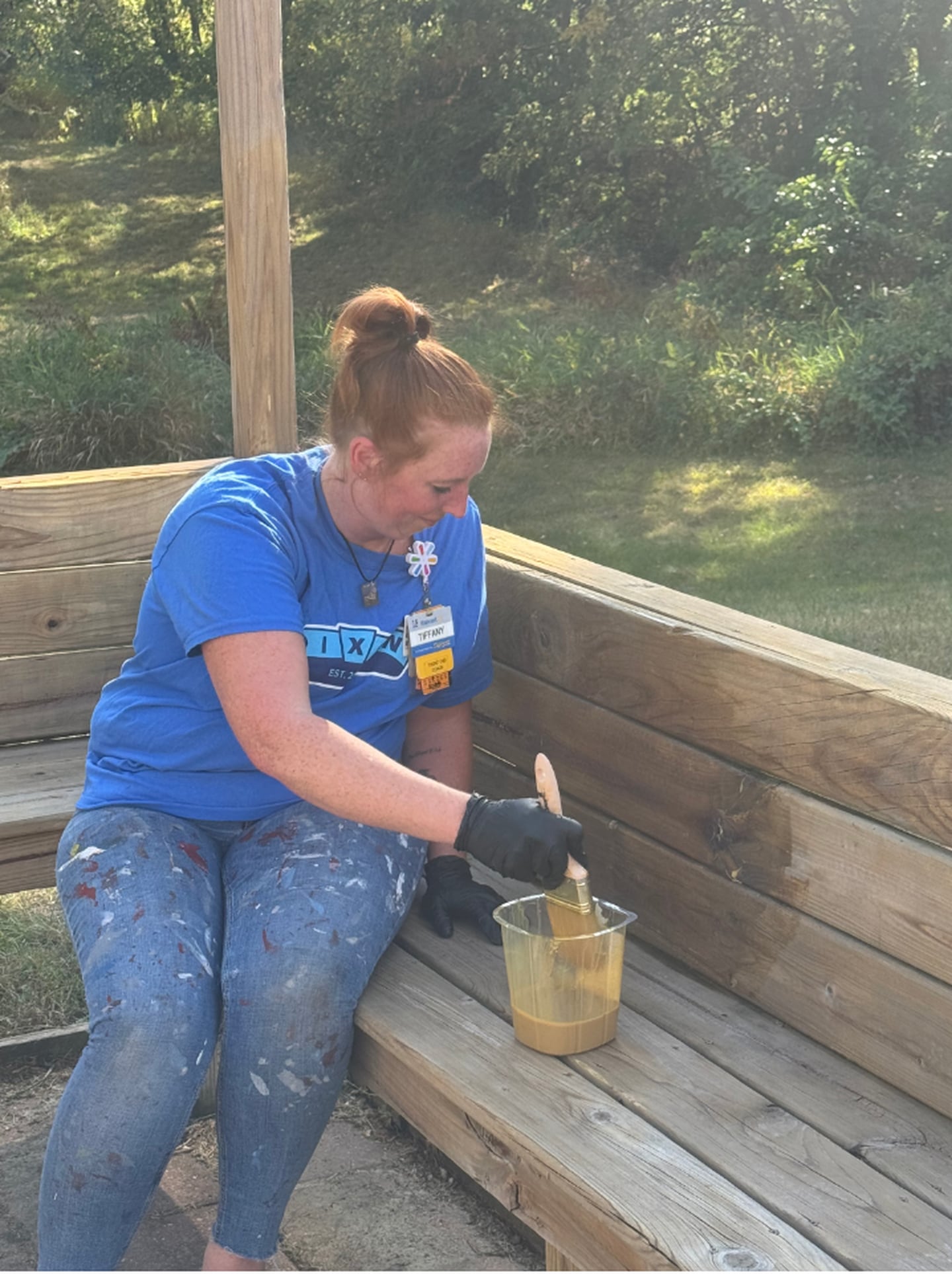 Walmart Coach Tiffany Otten staining the patio furniture at the Hope Cancer Wellness Center in Dixon.