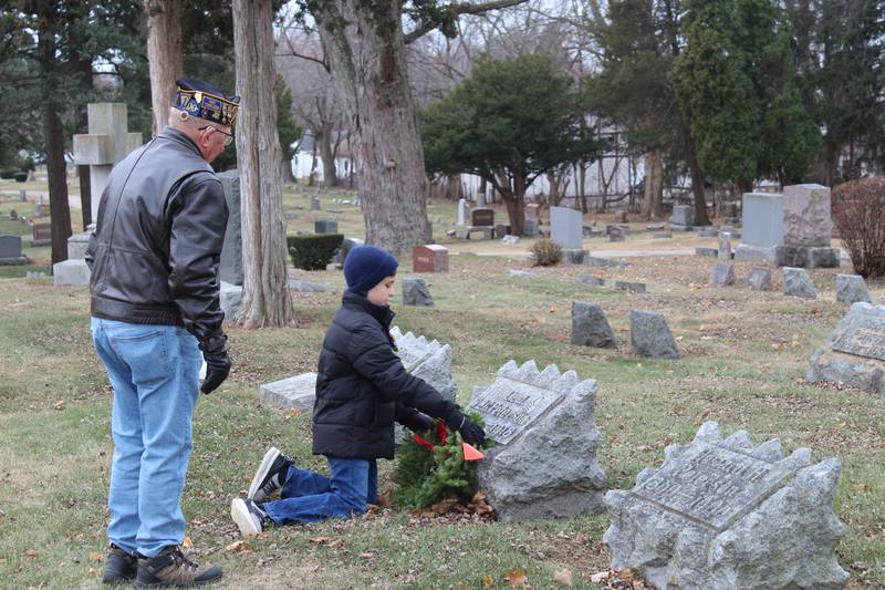 A Boy Scout from Troop #165 salutes to a Gold Star veteran's headstone during the Wreaths Across America ceremony in Crystal Lake on Dec. 14, 2024.