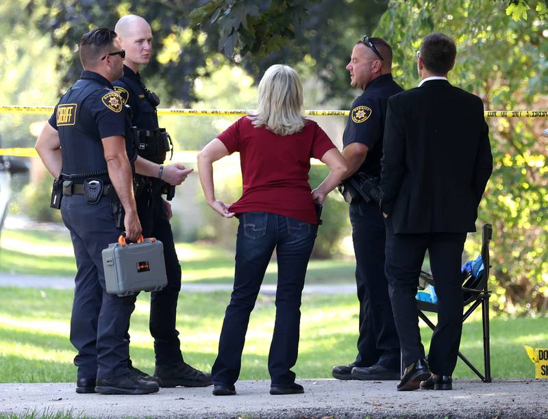 DeKalb County sheriff’s deputies and other investigators talk Tuesday, Sept. 30, 2025, in the driveway of a house in the 1300 block of Oakland Drive in Sycamore where two people were found dead Tuesday morning.