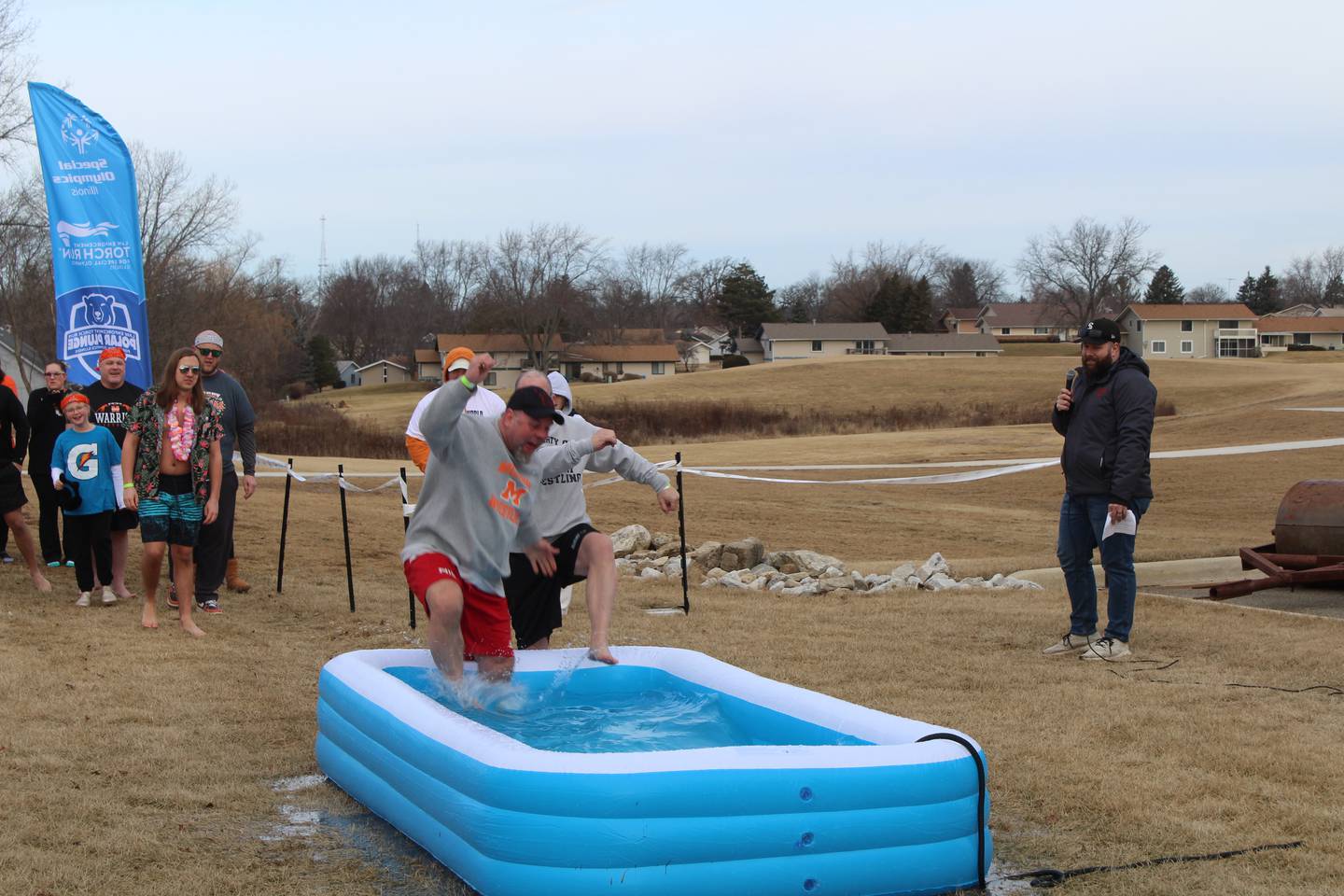 McHenry Community High School wrestling coach Donnie Hallin jumps in an inflatable pool for the school's first polar plunge on Feb. 1, 2025.