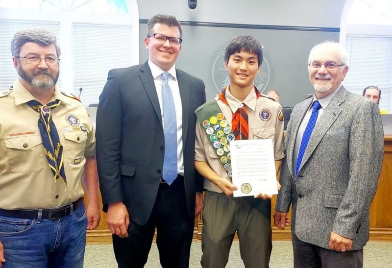 Cooper Merrinette, second from right, receives recognition for organizing a memorial ceremony for seven Villa Park military veterans whose cremated remains have been unclaimed for decades. He is flanked by his father, Jeff, left; Knollcrest-Steuerle funeral director Eric Shoesmith, second from left; and Villa Park Village President Nick Cuzzone. (Courtesy of Cooper Merrinette)