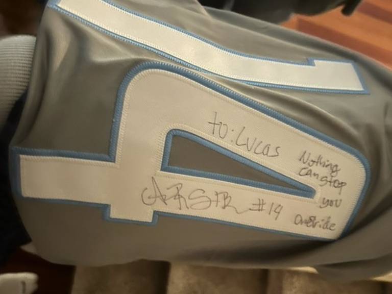 Lucas Gidelski's No. 14 jersey signed by Lions wide receiver Amon-Ra St. Brown.