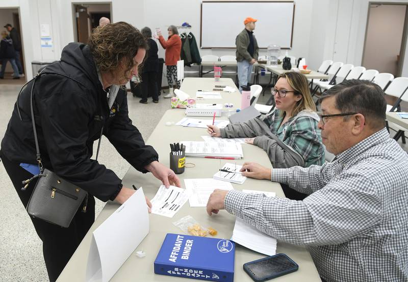 Kim Stahl, of Oregon, signs in to vote Tuesday, April 4, 2023, with the assistance of election judges Greg Tremble and Elsie DeVries.