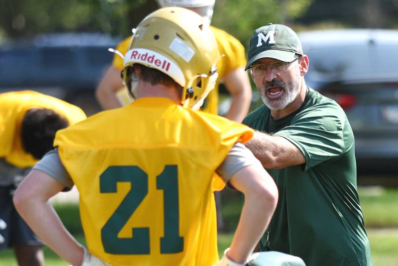 Bishop McNamara football coach Greg Youngblood, right, gives instructions to Jack Purcell during practice Monday, Aug. 11, 2025.