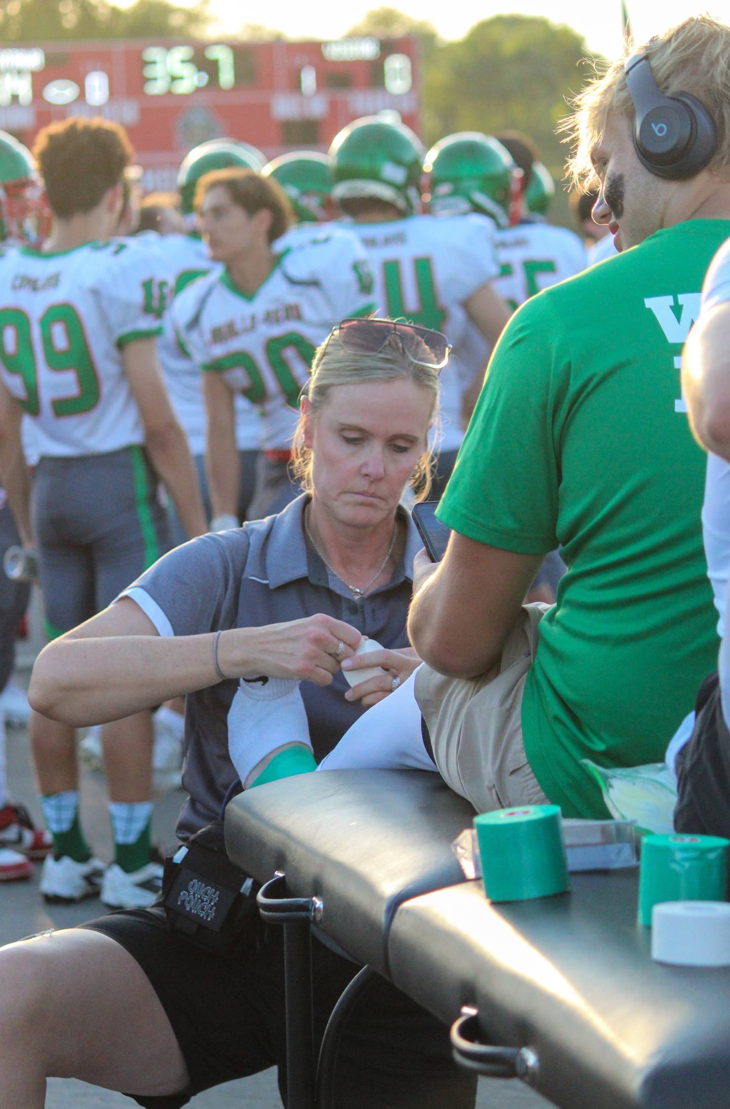 La Salle-Peru athletic trainer Gina Martin tapes a player's ankle.