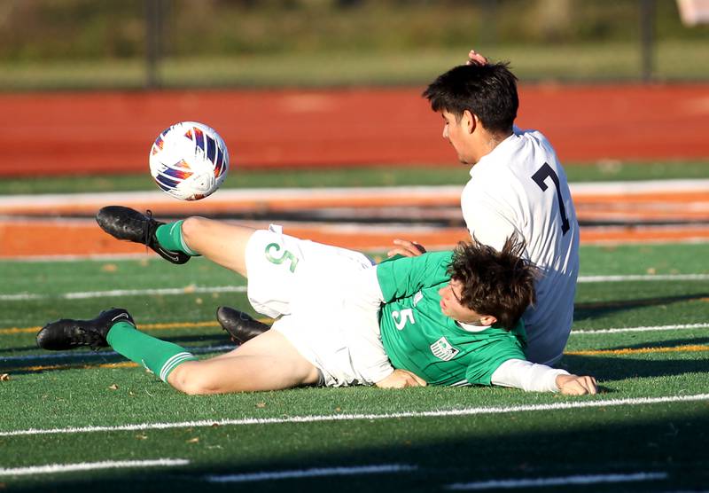 York’s Michael Greco (5) slides into the ball under Addison Trail’s Emilio Macias during a Class 3A St. Charles East Sectional semifinal game on Wednesday, Oct. 26, 2022.