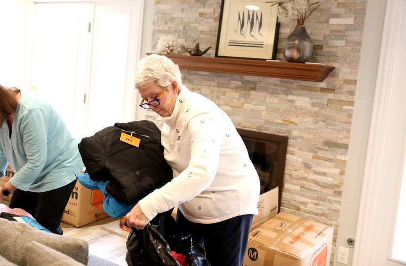 Margaret Blighton of Batavia (right) and Marge Brown sort  children’s winter coats to be donated to the Salvation Army, Lazarus House and area schools.