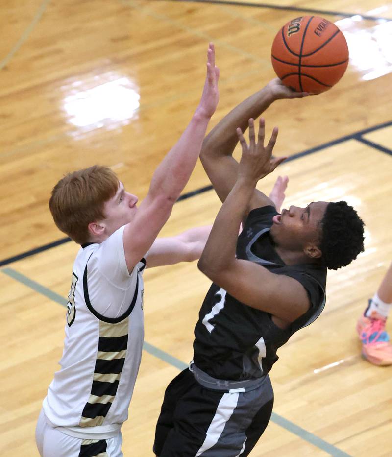 Kaneland's Gevon Grant shoots over Sycamore's Teague Hallahan during their game Friday, Feb. 10, 2023, at Sycamore High School.