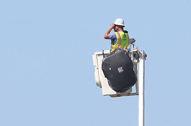 An AT&T worker helps authorities while using binoculars to try to locate a missing juvenile male along East 15th Road near Wallace Grade School on Wednesday, Aug. 30, 2023 north of Ottawa. Wallace Fire Department, Illinois State Police and Ottawa Police Department were called to the school shortly after a student who ran ran out of the school and into a cornfield.