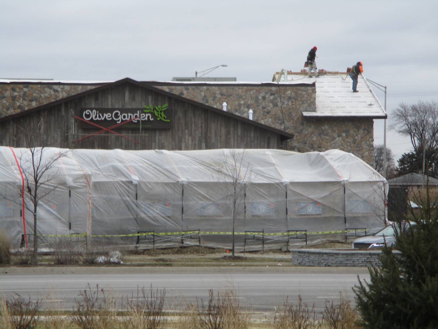 Workers can be seen Friday, Jan. 13, 2023 on the roof of the Olive Garden restaurant under construction in Joliet.