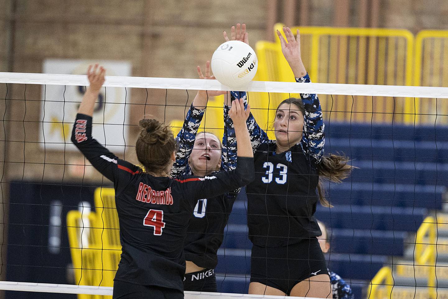 St. Francis’ Anna Paquette (left) and Emma Delaney work the net Friday, Nov. 4, 2022 during the Spartan’s 3A supersectional game against Metamora’s Victoria Hall.