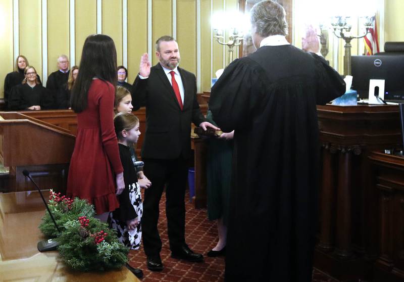 New DeKalb County State’s Attorney Riley Oncken, accompanied by his family, is sworn in by Chief Judge Bradley Waller Monday, Dec. 2, 2024, at the DeKalb County Courthouse in Sycamore.