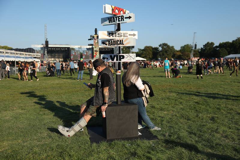 A couple rest at one of the direction signs on day one of Riot Fest, Friday, Sept. 15, in Chicago.