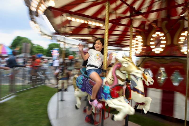 Ariana Gamboa, 6, of Lake in the Hills takes a spin on the merry-go-round during the Rockin’ Rib Fest Friday at Sunset Park in Lake in the Hills.