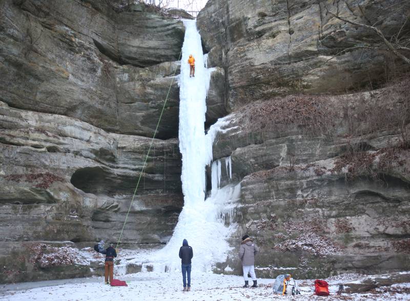 Gerry Voelliger of Bettendorf, Iowa, (top) climbs up a 80-foot frozen waterfall inside Wildcat Canyon on Friday, Jan. 24, 2025, at Starved Rock State Park.