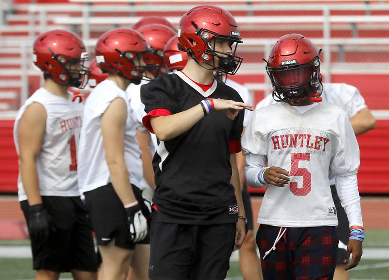 Huntley's Cole Copersmet talks with Bryce Walker during the first day of football practice Monday, August 7, 2023, at the Huntley High School’s Red Raider Stadium.
