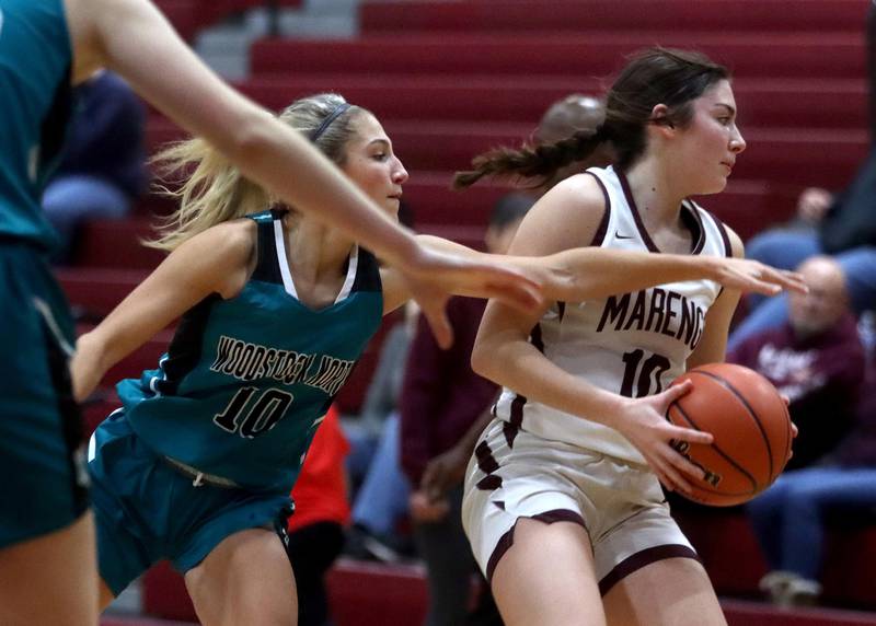 Marengo’s Bella Frohling, right, gets past Woodstock North’s Addison Rishling in girls basketball at Marengo on Thursday.