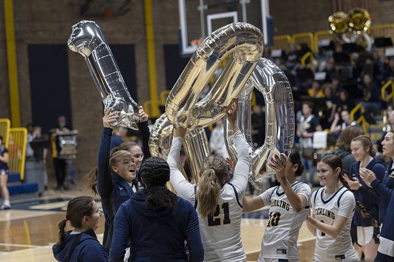 The Sterling girls basketball team celebrate teammate Joslynn James for scoring her 1,000 career point on Dec. 26.