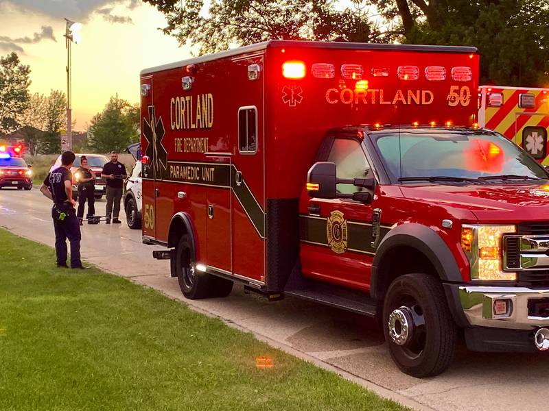Police and firefighters huddle around a Cortland ambulance as they prepare a drone to help assist a water rescue on Sunday, July 27, 2025, in the 600 block of Ridge Drive in DeKalb.