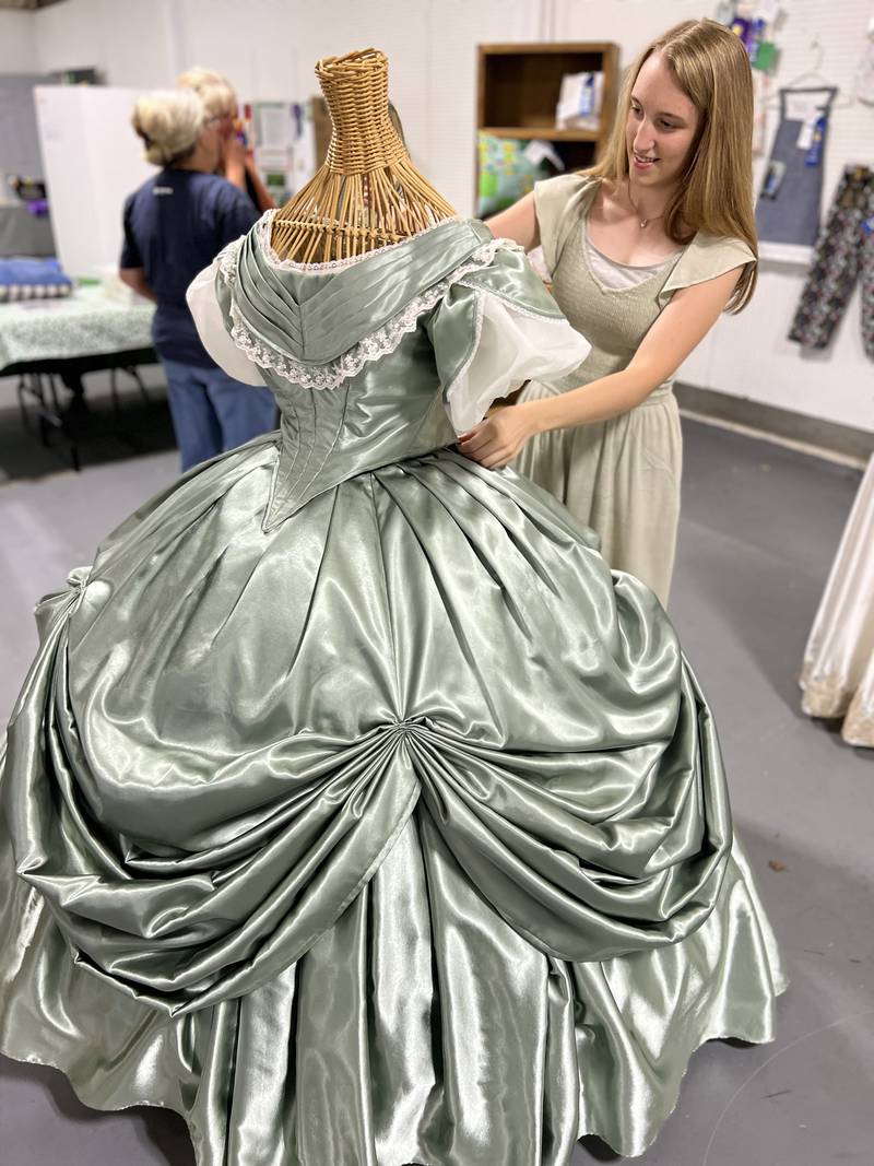 4-H graduate Ania Nelson of Yorkville carefully dresses a mannequin form to showcase her final 4-H sewing project, a period-piece that took her about 300 hours to complete.