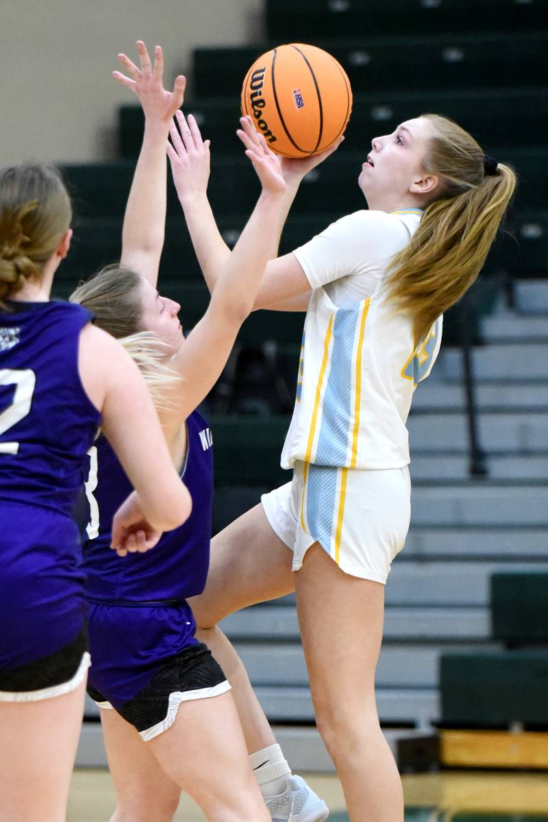 Joliet Catholic Academy's Abigail Dulinsky, right, shoots a layup over a pair of Wilmington defenders during an IHSA Class 2A Coal City Regional semifinal Tuesday, Feb. 18, 2025.