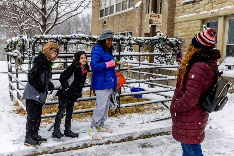 Romeoville resident Crystal Robison takes a photo of Anthony Baez, Ava Baez, and Londyn Robinson with the reindeer outside Lockport City Hall during Lockport’s Christmas in the Square festivities on Nov. 29, 2025.
