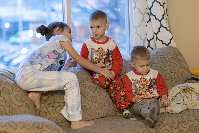 Nastya, 7, and twin brothers Bohdon and Roman, 3, spend time in the apartment furnished by a sponsorship group.