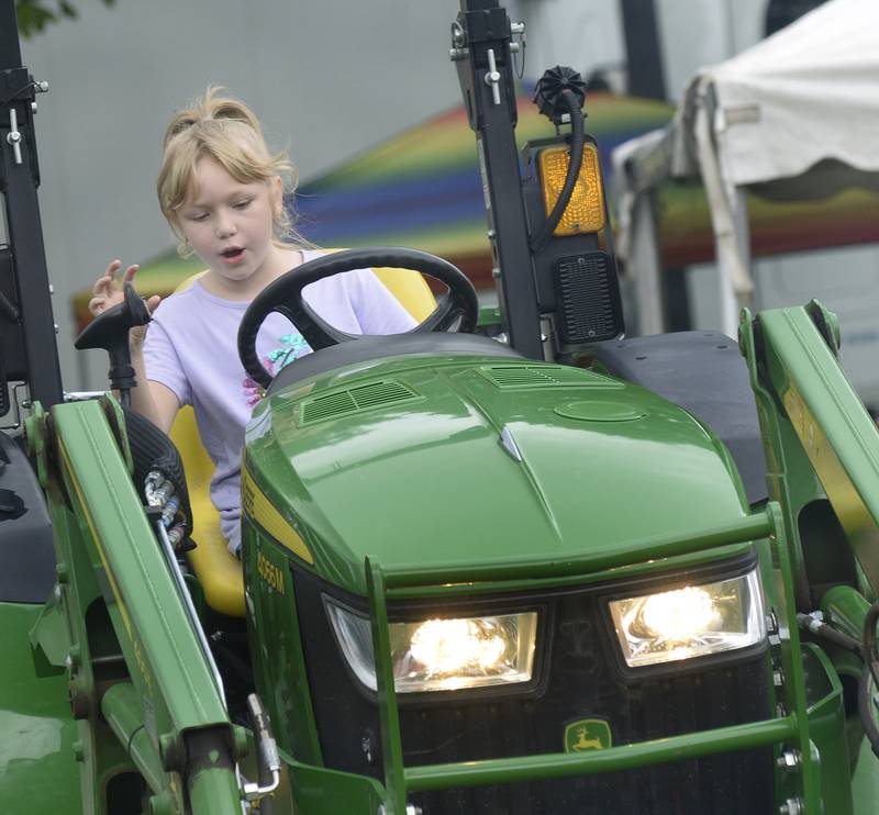 Emma Barbaro pretends to operate this John Deere tractor Sunday, July 28, 2024, during the Touch A Truck event in Ottawa. The event was sponsored by the Illinois Valley Contractors Association, the Illinois Valley Labor Management Fund and the Illinois Valley Trades.