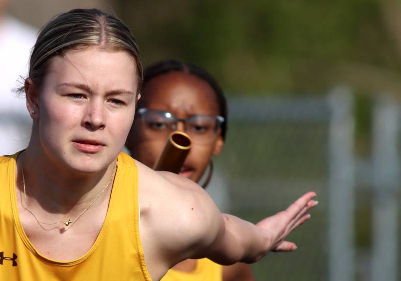 Jacobs’ Aaliyah Guichon, right, hands the baton to teammate Layla Merlin in the 400-meter-relay during the McHenry County Track and Field Meet at McCracken Field on Thursday, April 24, 2025, in McHenry
