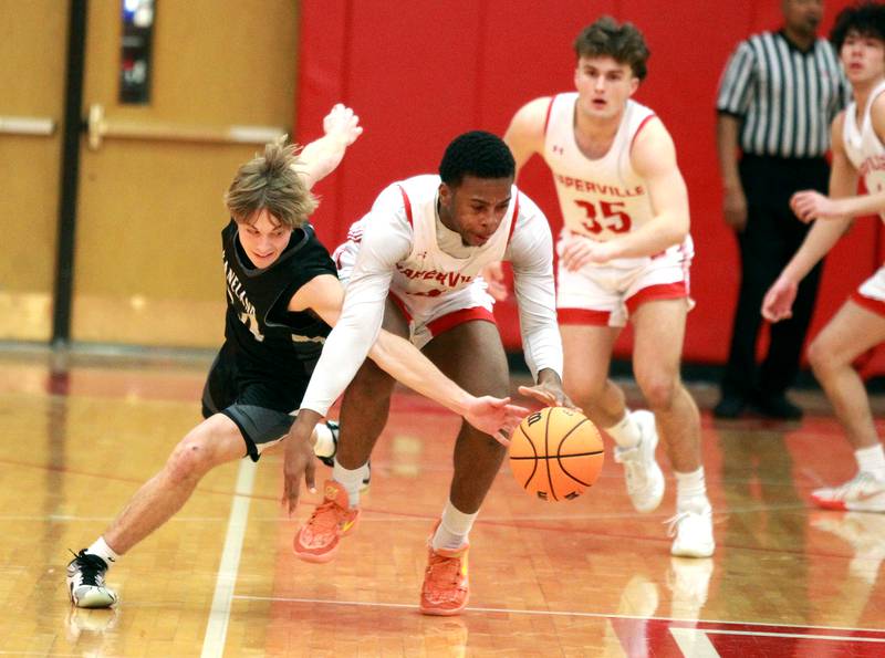 Kaneland's Luke Reinert and Naperville Central's Evan Moss go after the ball during a game on Tuesday, Jan. 14, 2025 in Naperville.