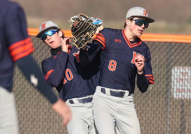 Naperville North's Caden Vorwick (right) makes a catch despite colliding with teammate Sam Steele Tuesday, April 15, 2025, during their game at DeKalb High School.