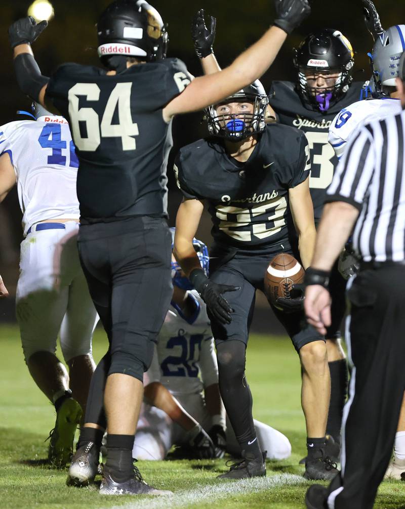 Sycamore's Dylan Hodges (middle) is greeted by his teammates after scoring a touchdown during their game against Woodstock Friday, Sept. 8, 2023, at Sycamore High School.