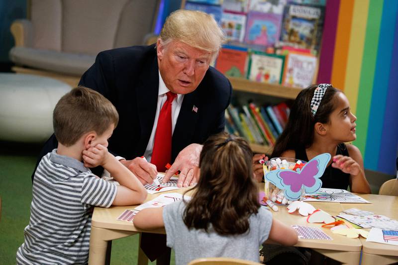 FILE - President Donald Trump colors during a visit with a group of children at the Nationwide Children's Hospital, Aug. 24, 2018, in Columbus, Ohio. (AP Photo/Evan Vucci, File)