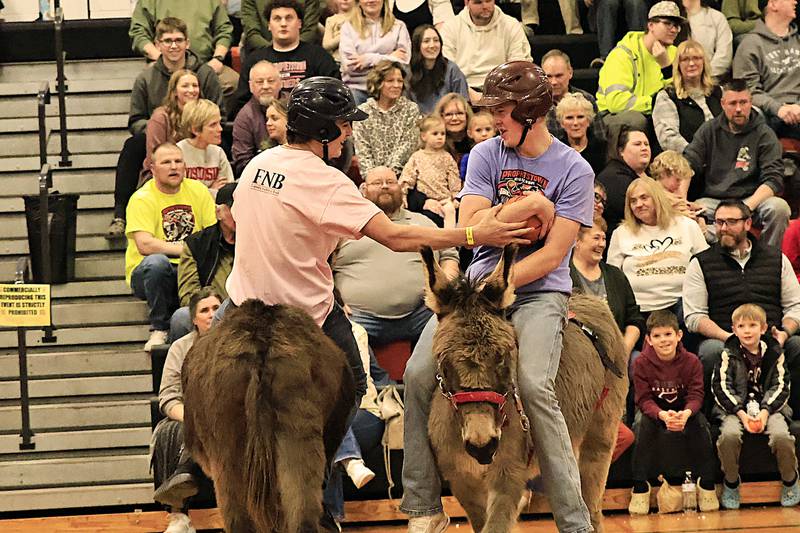 Owen Farral (right) guards the ball from Connor Johnson on Friday, March 13, 2026, while trying to stay mounted on his donkey.