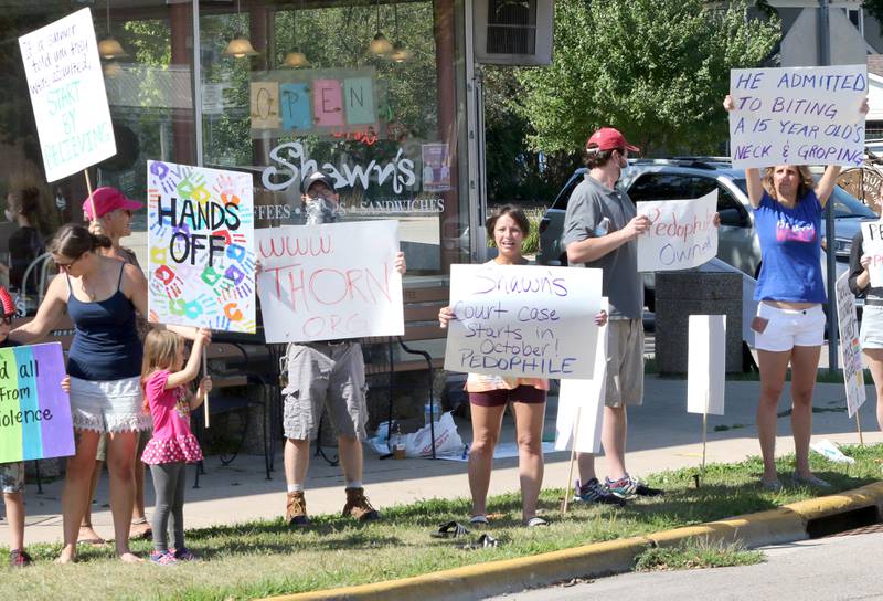 Protesters picket Friday in front of Shawn's Coffee Shop in Sycamore to inform the public of allegations that the owner, Shawn Thrower, committed misdemeanor battery against a 15-year-old employee. Thrower allegedly bit and inappropriately touched the employee.