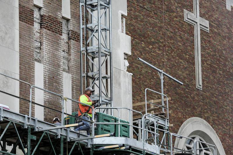 Construction crews work to repair the brick and masonry Tuesday, June 12, 2018, at the Cathedral of St. Raymond Nonnatus in Joliet, Ill.