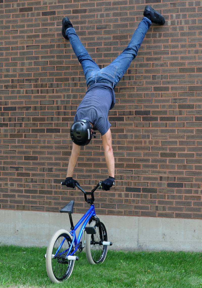Matt Wilhelm demonstrates his Spiderman skills as he climbs the exterior wall of the Reddick Library in Ottawa on Thursday, July 28, 2022, during a show that also included positive motivational messages.