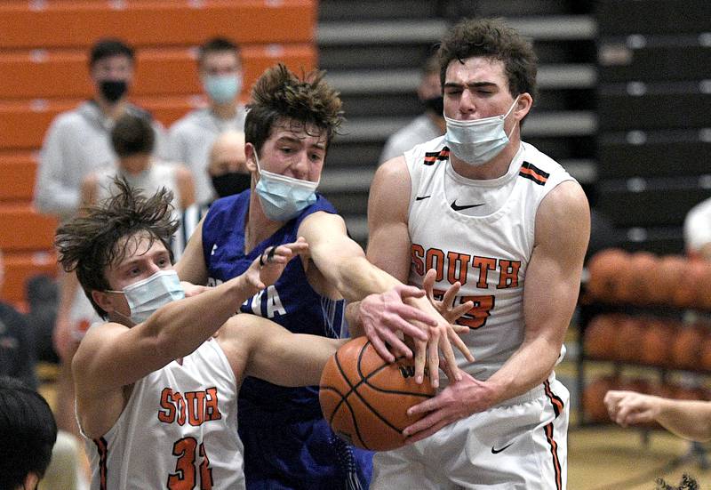 Wheaton Warrenville South's Matthew Sommerdyke and Tyler Fawcett fight with Geneva's Ryan Huskey for the rebound during the varsity basketball matchup in Wheaton on Wednesday, March 3, 2021.