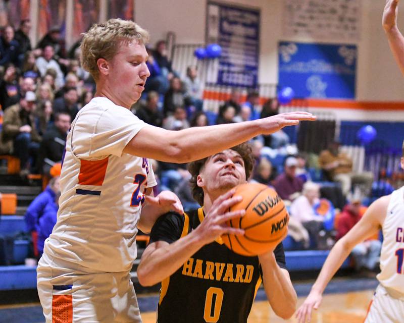 Harvard's Adam Cooke (0) makes a basket while being defended by Genoa-Kingston's Hayden Hodgson (23) during the game on Thursday Feb. 13, 2025, held at Genoa-Kingston High School.