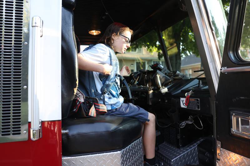 4th grader William Zaffino gets set to ride to school in the front seat of a fire truck. William won a raffle to get a ride in a fire truck to his first day of school at Eisenhower Academy in Joliet. Wednesday, Aug. 17, 2022, in Joliet.
