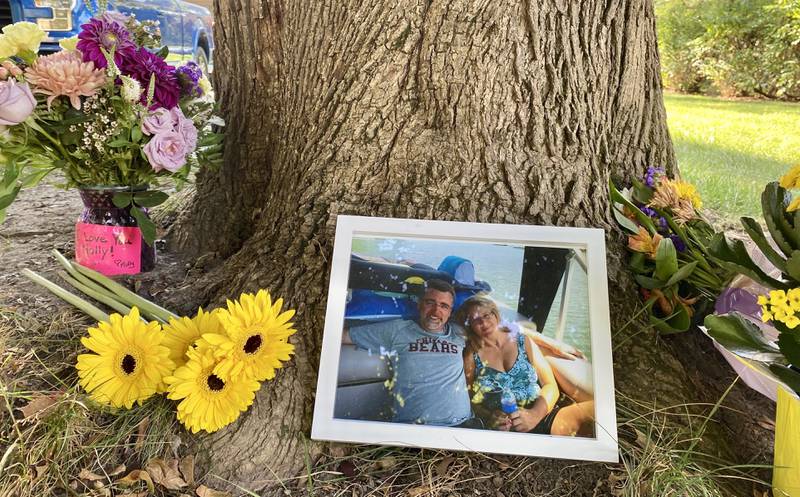 Memorial flowers, a photo and messages of love were placed outside the home of Gary Schmidt and Holly Schmidt on Friday, Oct. 3, 2025, on Oakland Drive in Sycamore. The Schmidts, shown in the photo, were found dead in their home on Tuesday, authorities said.