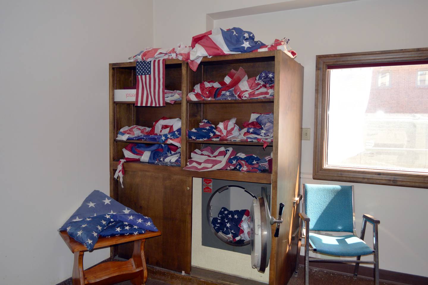 American flags rest on shelves and in a drop box on Saturday, Sept. 28, 2024, in the building at 101 W. Mason St., Polo. Flags dropped off will be properly disposed of. Cotton ones will be burned in a ceremony and the others will be provided to local funeral homes to be cremated with veterans as part of Patrick Fegan American Legion Post No. 83's new Farewell Flags program.